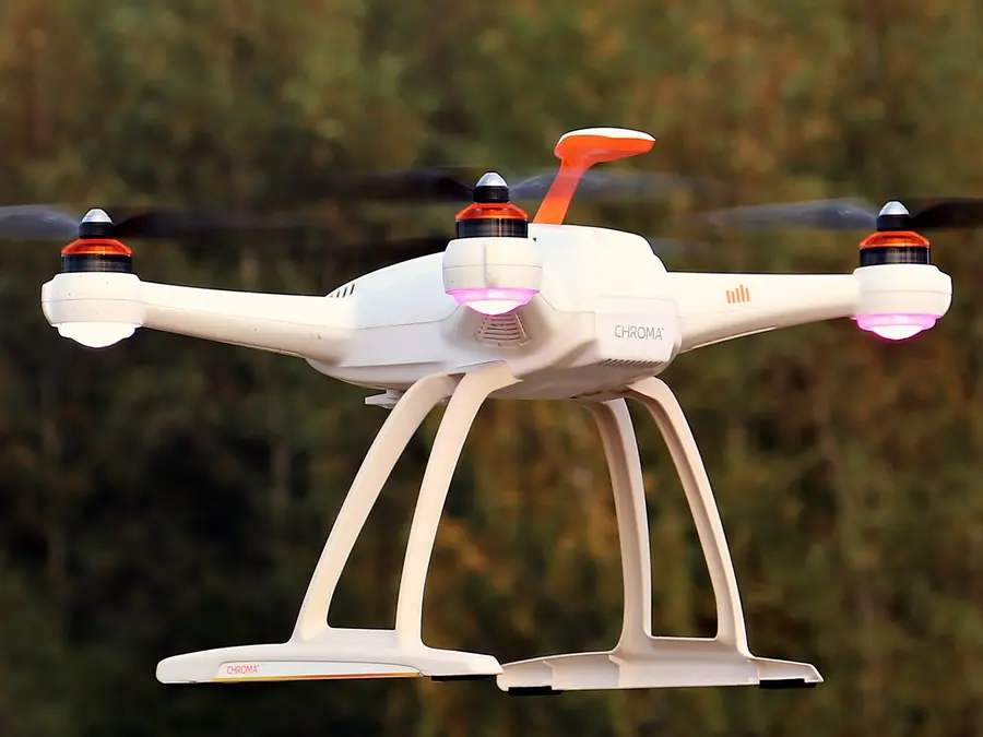 Witte drone met vier rotoren in de lucht
